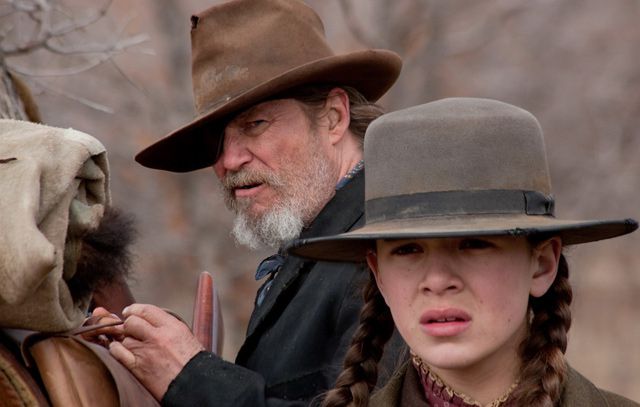 The Western that earned John Wayne an Oscar over 40 years ago returns to the screen this weekend, re-envisioned by the Coen brothers. True Grit stars newcomer 14-year-old Hailee Steinfeld as the fearless and stubborn Mattie Ross, a girl determined to track down outlaw Tom Chaney (Josh Brolin), her father's killer. Jeff Bridges plays U.S. Marshal Rooster Cogburn, and he joins the manhunt with LeBoeuf (Matt Damon), a Texas Ranger who seeks to take the killer back to Texas for the murder of another man. Mattie must enlists the help of Cogburn to find her father's murderer before LeBoeuf by entering Indian territory.Reviews have been almost fairly positive, with Peter Travers of Rolling Stone glowing, "What makes True Grit a new classic for the Coens is the way the brothers absorb the unfairly unsung Portis into their DNA, like they did with Cormac McCarthy in No Country for Old Men. True Grit is packed with action and laughs, plus a touching coda with an older Mattie, but it's the dialogue that really sings. Great filmmaking. Great acting. Great movie. Saddle up."